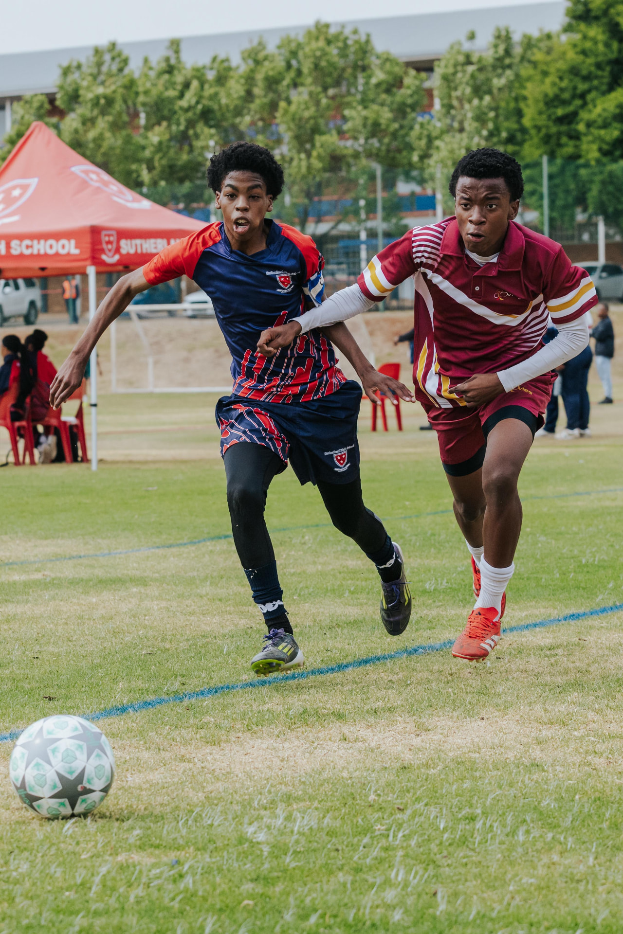 Two players competing for the ball during a Suthies Football Challenge match